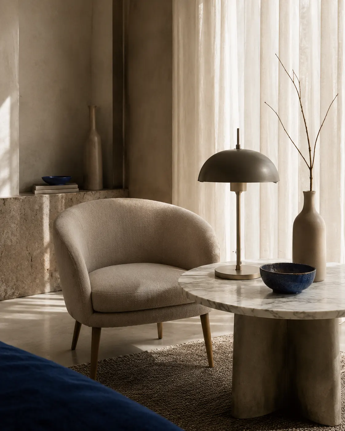 Interior contemporáneo con sillón, mesa de mármol y lámpara de Estudio 17
